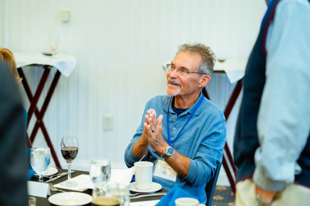 An alumnus clapping his hands together at the Reunion Dinner.